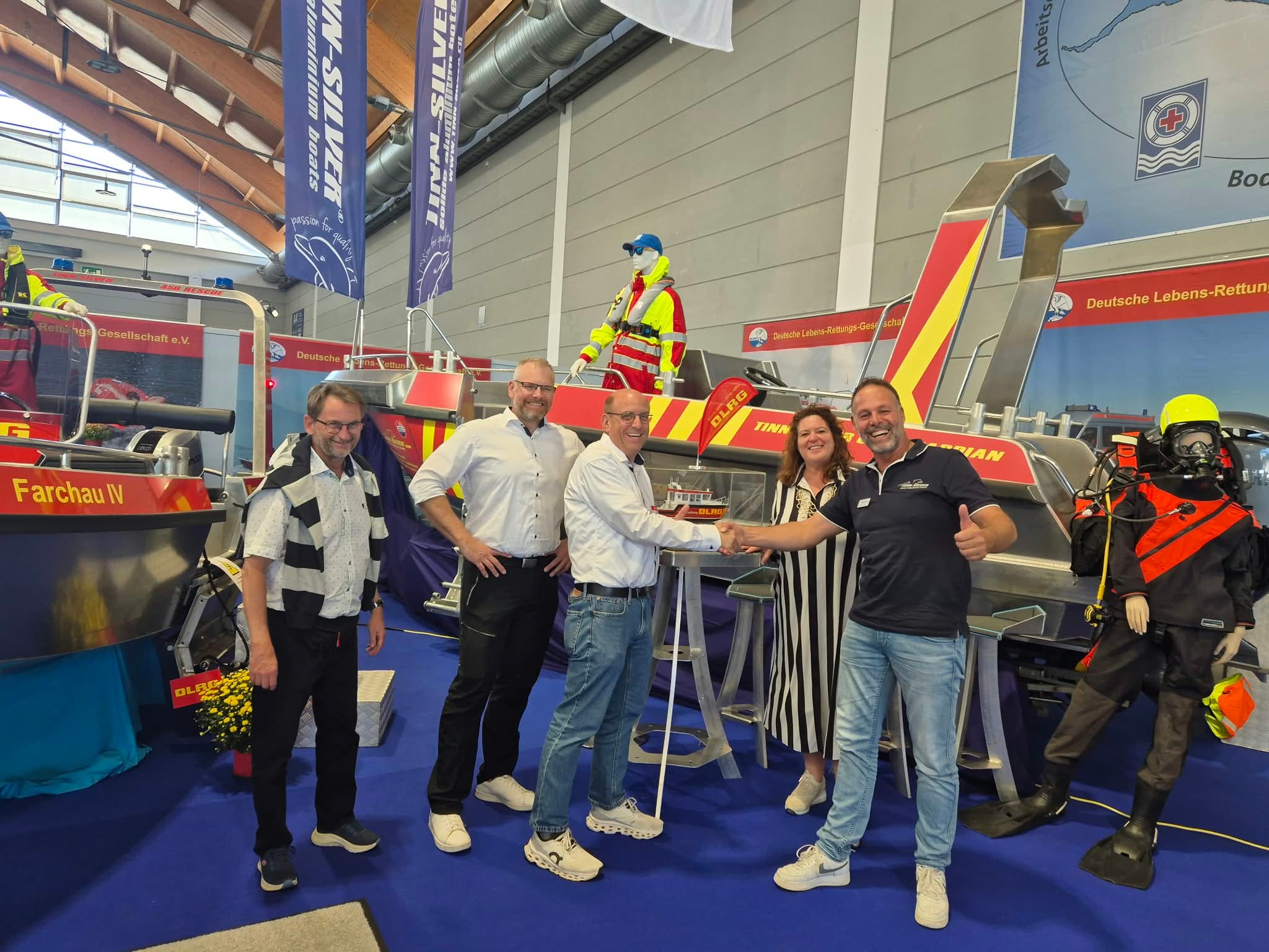 Group photo with a handshake at the Tinn-Silver stand at Interboot