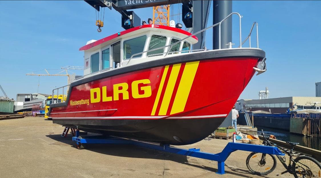 Red DLRG rescue boat on a transport trailer at the shipyard